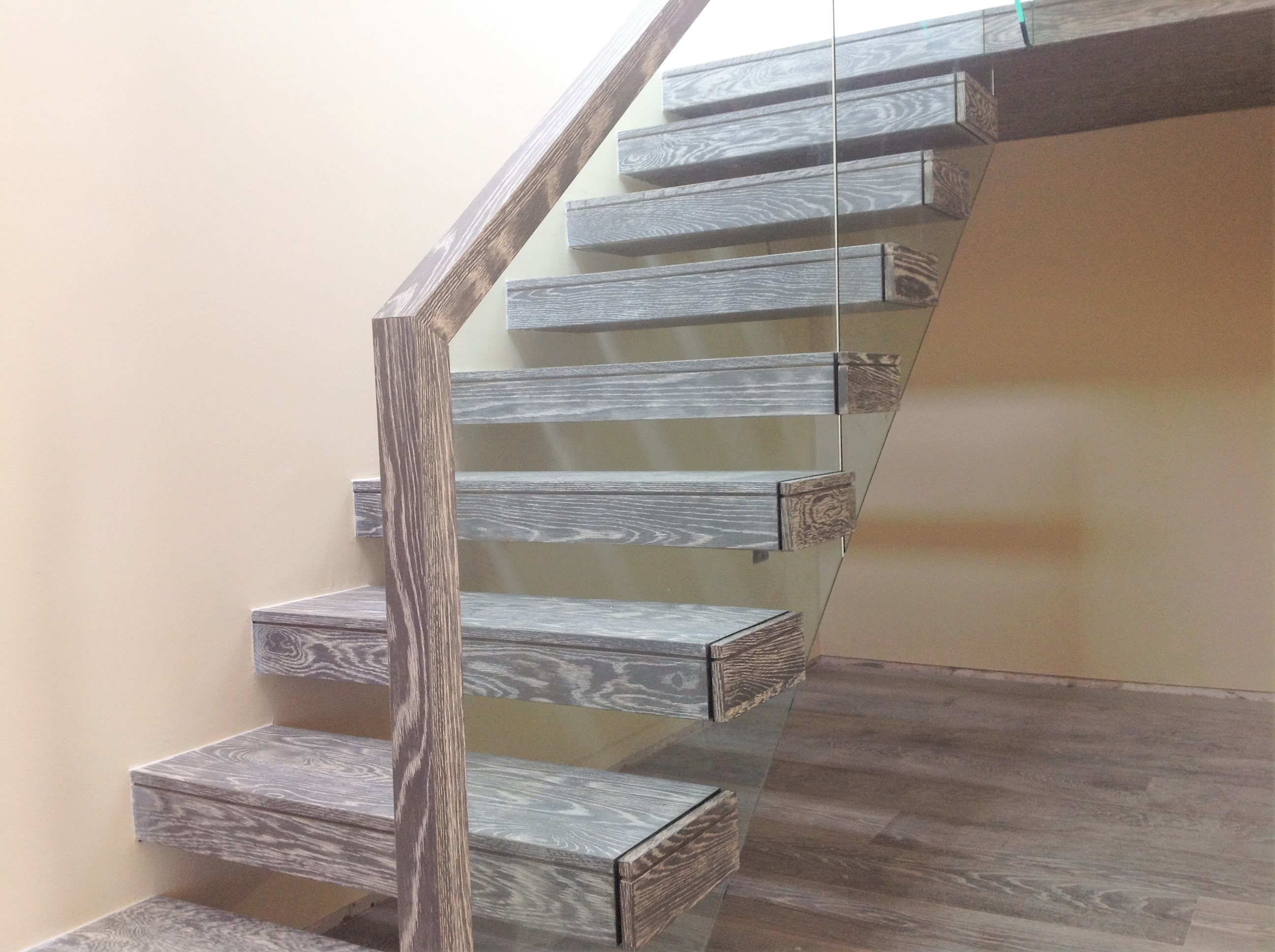 Modern Cantilevered stairs ireland with glass balustreade stained in grey